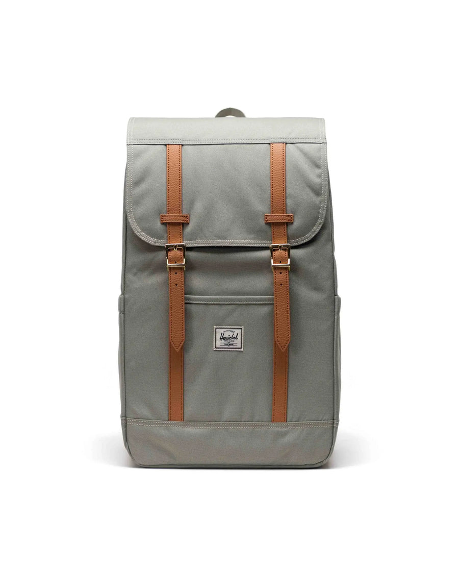 Herschel Retreat backpack in seagrass green, featuring drawstring closure, leather straps, and classic surf-lifestyle styling.